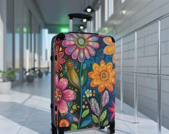 May include: A black suitcase with a colorful floral design featuring pink, yellow, orange, green, and blue flowers. The suitcase has a retractable handle and four wheels.