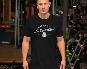 May include: Black t-shirt with white text that reads "Like Whisky I'm Well Aged" with a graphic of stacked barrels and the words "Scotch Whisky".