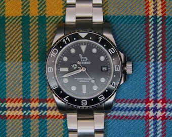May include: A stainless steel wristwatch with a black dial and a rotating bezel featuring white numerals. The dial displays a graphic of a recliner chair with the text RETIRED, along with the words NO TENSION JUST PENSION OFFICIALLY RETIRED NO MORE 9-5.
