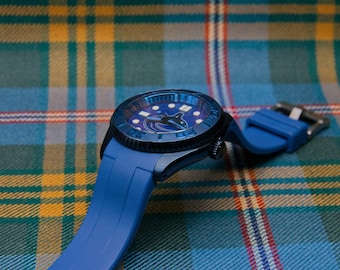 May include: A blue wristwatch featuring a dark blue bezel and a matching blue silicone strap. The watch face displays a graphic of a black and white orca whale, with luminous hour markers and a silver-toned buckle on the strap.