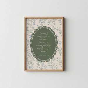 May include: Framed art print with a light wood frame. The artwork features a floral background with a central oval containing the text "Before I formed you in the womb, I knew you, before you were born I set you apart." Jeremiah 1:5.
