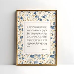 May include: Framed print featuring Psalm 23 text. The frame is gold, and the print has a floral pattern in blue and cream. The text is centered within a white border, offering a classic and elegant aesthetic.