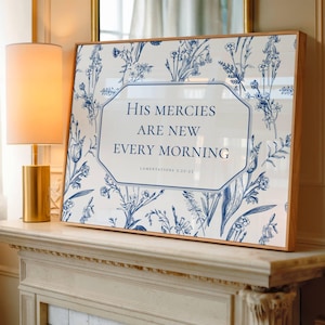 May include: Framed art print with a floral pattern in blue and white. The print features the text "His mercies are new every morning" in a decorative frame. The frame is made of light-colored wood.