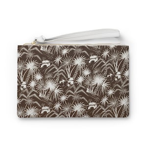 May include: A brown clutch purse with a white zipper and a white strap. The purse has a white print of palm trees and buildings on a brown background.