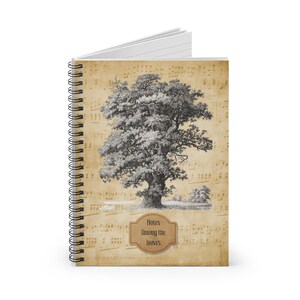 Peut inclure: Cahier à spirales avec une illustration sépia d'un grand arbre sur un fond de partitions musicales. La couverture porte l'inscription "Notes Among the Leaves" dans un cadre marron. Reliure à spirale noire.