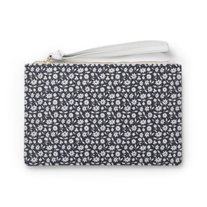 May include: A small, black zippered pouch with a white floral pattern and a white strap.