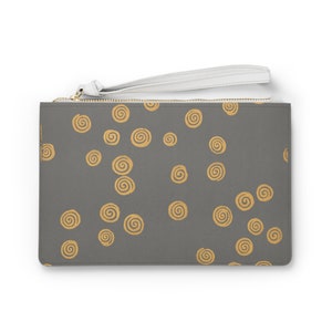 May include: A gray clutch purse with a white zipper pull and a gold chain. The purse has a repeating pattern of gold swirls on the front.