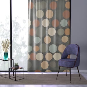 May include: A blue velvet chair with a curved back and a gray curtain with a polka dot pattern in shades of brown, beige, and blue.