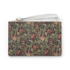 May include: A black clutch purse with a white zipper and a floral pattern. The pattern features red, green, and gold colors.