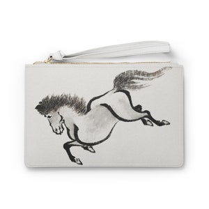 Puede incluir: Una cartera de mano blanca con cierre de cremallera y un dibujo a tinta negra y blanca de un caballo corriendo. El caballo está en una pose dinámica con las patas extendidas y la cola fluyendo detrás de él.