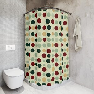 May include: A shower curtain with a polka dot pattern in shades of green, red, and yellow on a cream background.