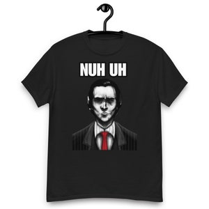 Puede incluir: Camiseta negra con un gráfico blanco de un hombre con traje y corbata. El texto "NUH UH" está por encima de la cabeza del hombre.