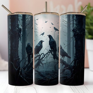 May include: Three stainless steel tumblers with a dark forest scene and ravens. The tumblers have a black background with a dark blue and gray forest scene. There are several ravens in the scene, some perched on branches and others flying in the air.
