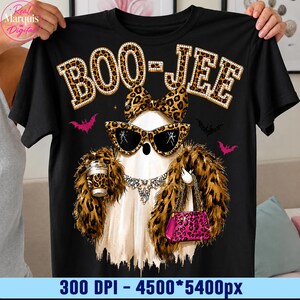 May include: A black t-shirt featuring a graphic of a white ghost wearing leopard print sunglasses, a matching bow, and a faux fur stole. The ghost holds a leopard print cup and a pink leopard print handbag. The text BOO-JEE is printed above.