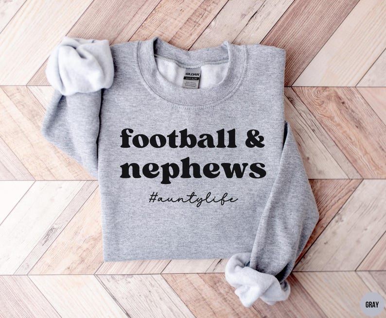 May include: Gray sweatshirt with the text "football & nephews #auntilyfe" printed in black.