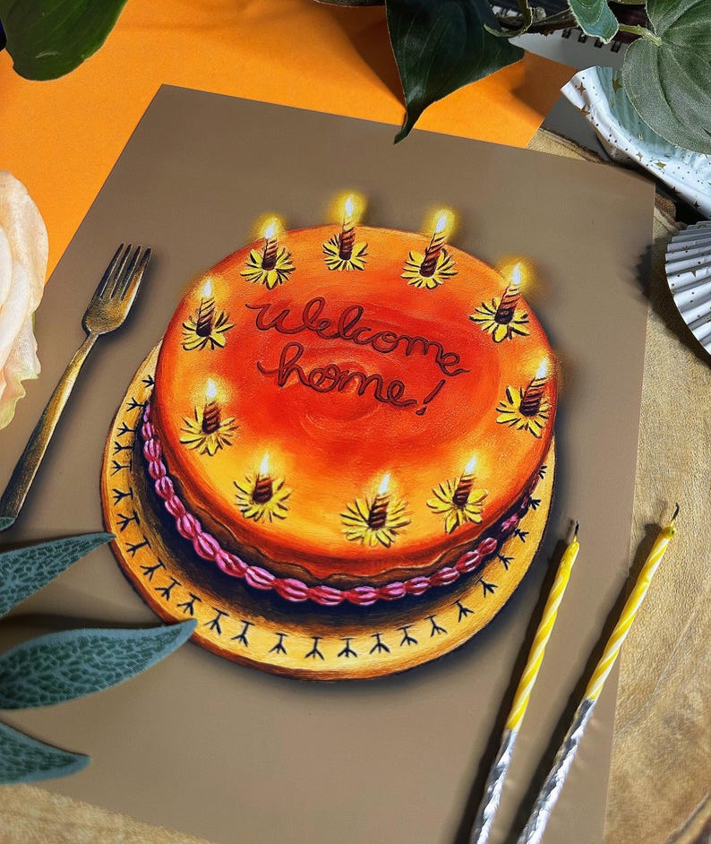 May include: A colorful illustration of a cake with lit candles. The cake is orange with the words "Welcome home!" written in red. The cake sits on a yellow plate with a decorative edge. Two yellow candles and a gold fork are also visible.
