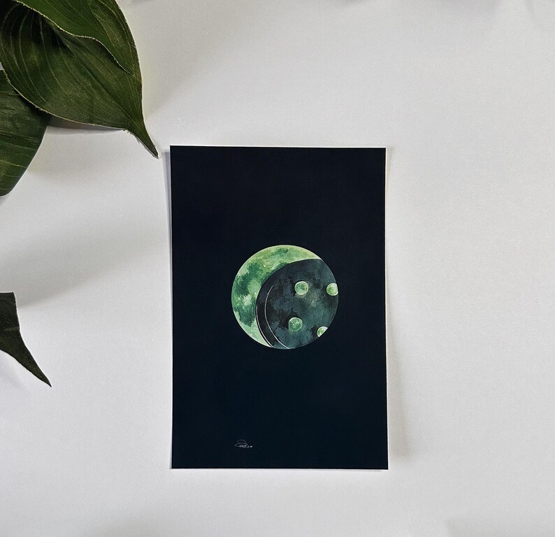 May include: A watercolor painting of a green moon with dark green craters on a black background.