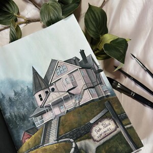 May include: A watercolor painting of a pink house with a sign that reads "Pink Palace Apartments". The house is on a hill with a stone wall and a path leading up to it. The painting is surrounded by green foliage.