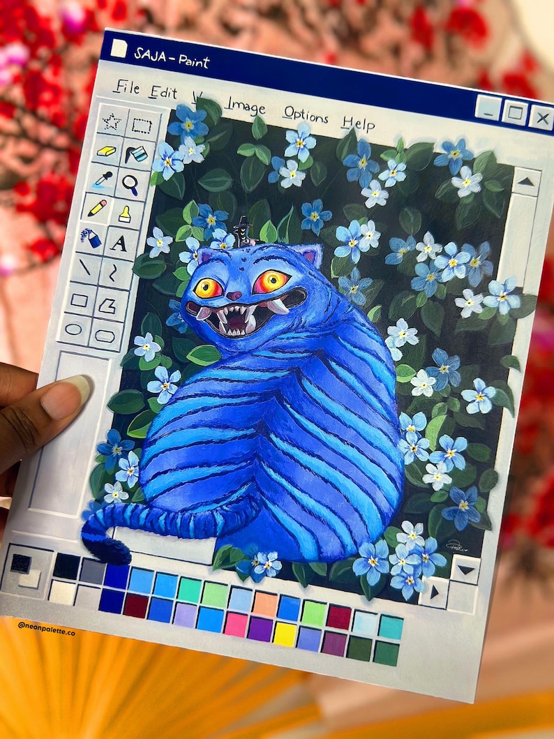 May include: A painting depicting a blue tiger-like creature with yellow eyes and sharp teeth, surrounded by blue flowers and green leaves. The artwork is framed within a retro computer window, labeled "SAJA-Paint". A color palette is visible at the bottom.