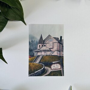 May include: A watercolor painting of a pink house with a white porch and a sign that reads "Pink Place Apartments". The house is surrounded by trees and a stone wall.