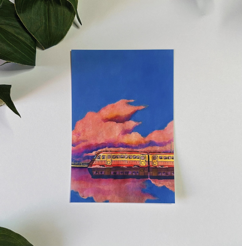 May include: A painting of a yellow and red train traveling through a pink and blue sky with fluffy clouds. The train is reflected in the water below.