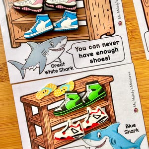 May include: An educational card with cartoon shoes and sharks. The card has the text "You can never have enough shoes!" and "One two buckle my shoe...". The shoes are in various colours, including pink, blue, green, and red.