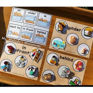 May include: Educational materials featuring cards with illustrations of objects and the words "on," "under," "in," "next to," "in front," and "behind." The cards have various miniature charms and the text "Ms. Melody's Miniatures."