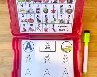 Puede incluir: Una caja de almacenamiento de plástico rosa que contiene tarjetas didácticas del alfabeto y un rotulador de borrado en seco. La tarjeta superior muestra una tabla del alfabeto con imágenes correspondientes. Las tarjetas didácticas presentan la letra "A" y ejercicios de trazado.