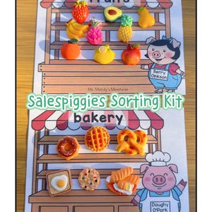 Peut inclure: Un kit de tri Salespiggies coloré avec des fruits et des produits de boulangerie miniatures. L'étagère supérieure présente une fraise, un avocat, une banane, un ananas et une poire. L'étagère inférieure montre un beignet, une tarte, un bretzel, du pain grillé, un biscuit et un sandwich. Le kit comprend deux personnages de cochons.