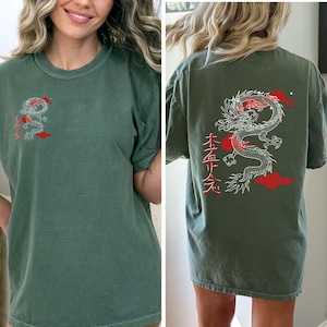 May include: A green t-shirt with a white dragon graphic and red kanji characters on the front and back. The dragon is surrounded by red clouds. The kanji characters on the front read "本金" and the kanji characters on the back read "金玉"