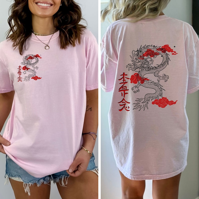May include: Pink oversized t-shirt with a black and red dragon graphic and the text "本命 天" on the back. The front of the shirt has a smaller version of the dragon graphic and the same text.