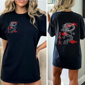 May include: Black oversized t-shirt with a white dragon and red clouds graphic on the back. The graphic also includes Japanese text.
