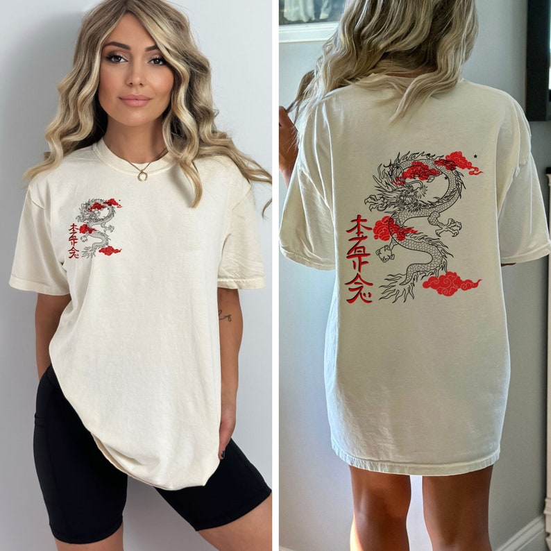 May include: A cream colored t-shirt with a black and red dragon graphic and Japanese characters on the back. The shirt is oversized and has a relaxed fit.