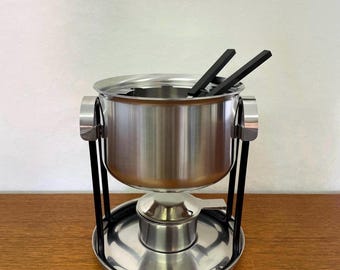 Zestaw do fondue Stelton autorstwa Erika Magnussena wykonany ze stali nierdzewnej z grawerunkiem w stylu lat 80.