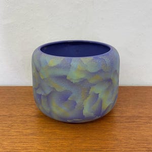 Könnte beinhalten: Ein kleiner, runder Keramiktopf mit einer blauen und grünen Marmorierung.