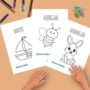 May include: Three coloring pages with illustrations of a boat, a bee, and a rabbit. The pages have the words "ABEJA", "BOTE", and "CONEJO" printed above the images. Colored markers and paper clips are scattered around the pages.