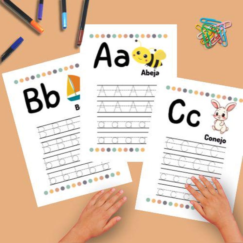 May include: Three white letter tracing worksheets with the letters A, B, and C. Each sheet has a colorful border and a corresponding image: a bee, a sailboat, and a rabbit. Pens and paperclips are also visible.