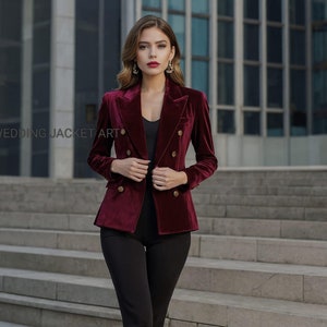May include: A burgundy velvet blazer with gold buttons. The blazer has a double-breasted closure and a notched lapel.