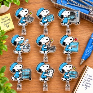 May include: Nine acrylic badge reels featuring Snoopy dressed in blue medical scrubs and a surgical cap. Each reel depicts Snoopy performing various sterile processing tasks, including washing hands, holding a clipboard, and handling medical equipment.