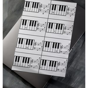 May include: A black and white printable piano keyboard chart with musical notes and the letters C, D, E, F, G, A, B, and C.