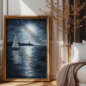 May include: A framed painting of a sailboat on a dark blue sea under a full moon. The moon is reflecting on the water. A lighthouse is visible in the distance.