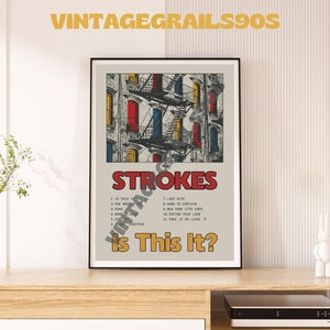 May include: A vintage poster for the Strokes album "Is This It?" featuring a photo of a building facade with fire escapes and a red, yellow, and blue colour scheme. The album title and tracklist are printed in black and white text.