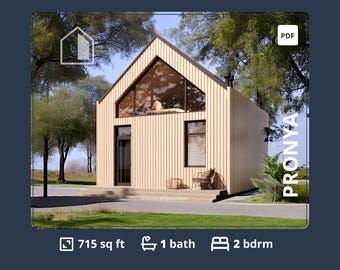 May include: A wooden house with a large window and a pitched roof. The house is 715 square feet and has 1 bathroom and 2 bedrooms. The house is surrounded by trees and grass.