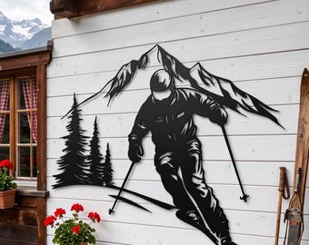 Op de afbeelding: Een zwart metalen wanddecoratie met het silhouet van een skiër in beweging, vasthoudend aan skistokken, voor een bergketen en een groep dennenbomen. Het ontwerp is vervaardigd uit een enkele platte plaat van donker metaal.
