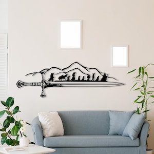 May include: Black metal wall art depicting a sword with a mountain range and a group of figures walking across the top. The art is mounted on a white wall above a grey sofa.