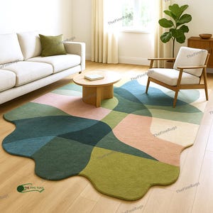 May include: An abstract design rug in a living room setting. The rug features a mix of green, blue, and pink shapes. The rug is placed on a wooden floor. The rug has an irregular, organic shape, adding a modern touch to the room.