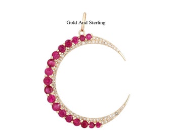 May include: A gold and sterling silver crescent moon pendant with a row of ruby stones and a row of smaller diamonds.