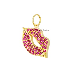 May include: Gold charm pendant in the shape of lips with pink gemstones.