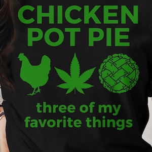 May include: Black t-shirt with green text that reads "Chicken Pot Pie three of my favorite things". The text is surrounded by a green chicken, a green marijuana leaf, and a green pie.