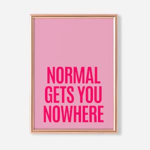 May include: A framed pink art print with the words "NORMAL GETS YOU NOWHERE" in bold, hot pink letters. The print has a light pink background and a thin, gold-colored frame. The artwork is a motivational piece.